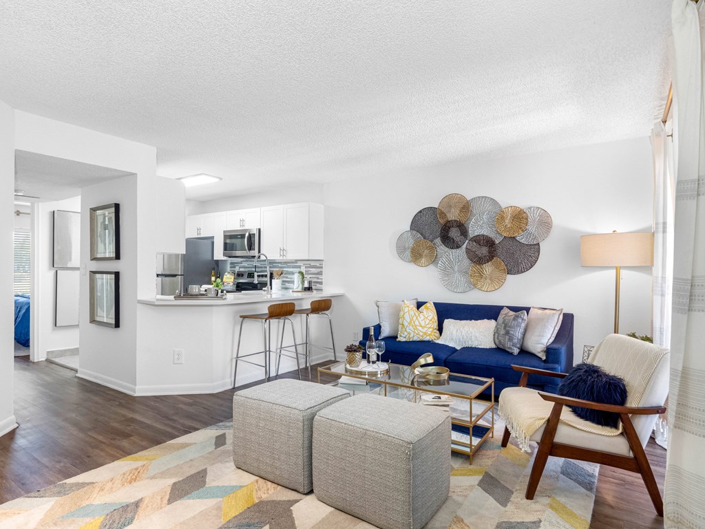 A modern living room with a blue couch and a wooden chair.